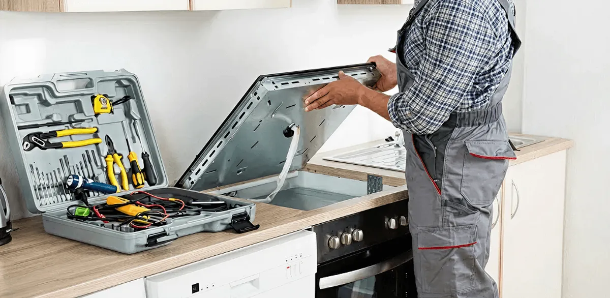 Handyman repairing a cooktop and checking wiring connections in Santa Ana, CA